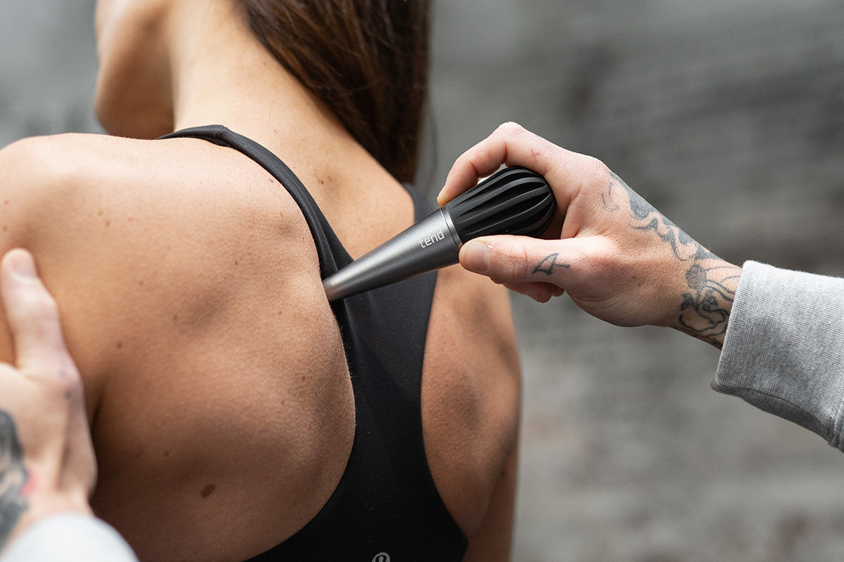 Tend owner using Tend Deep on gym partners shoulder and back